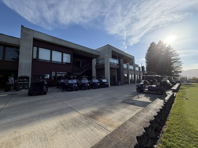 Crow Canyon Country Club clubhouse with golf carts lined up under a blue sky