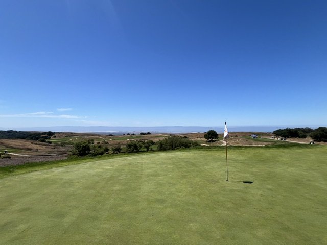 Putting green and flagstick at Stonebrae Country Club with panoramic San Francisco Bay views